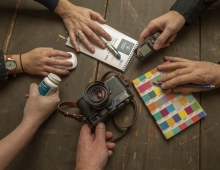 six hands holding office objects