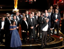 Group of actors on stage at the Oscars.