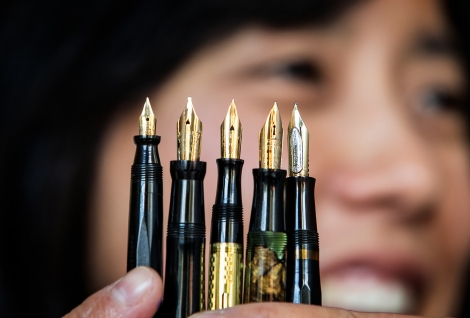 Tomoko Sakomura holds up a spray of five fountain pens