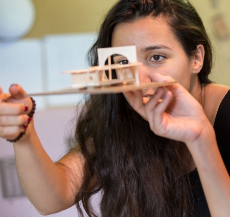 young woman looks up close at her model