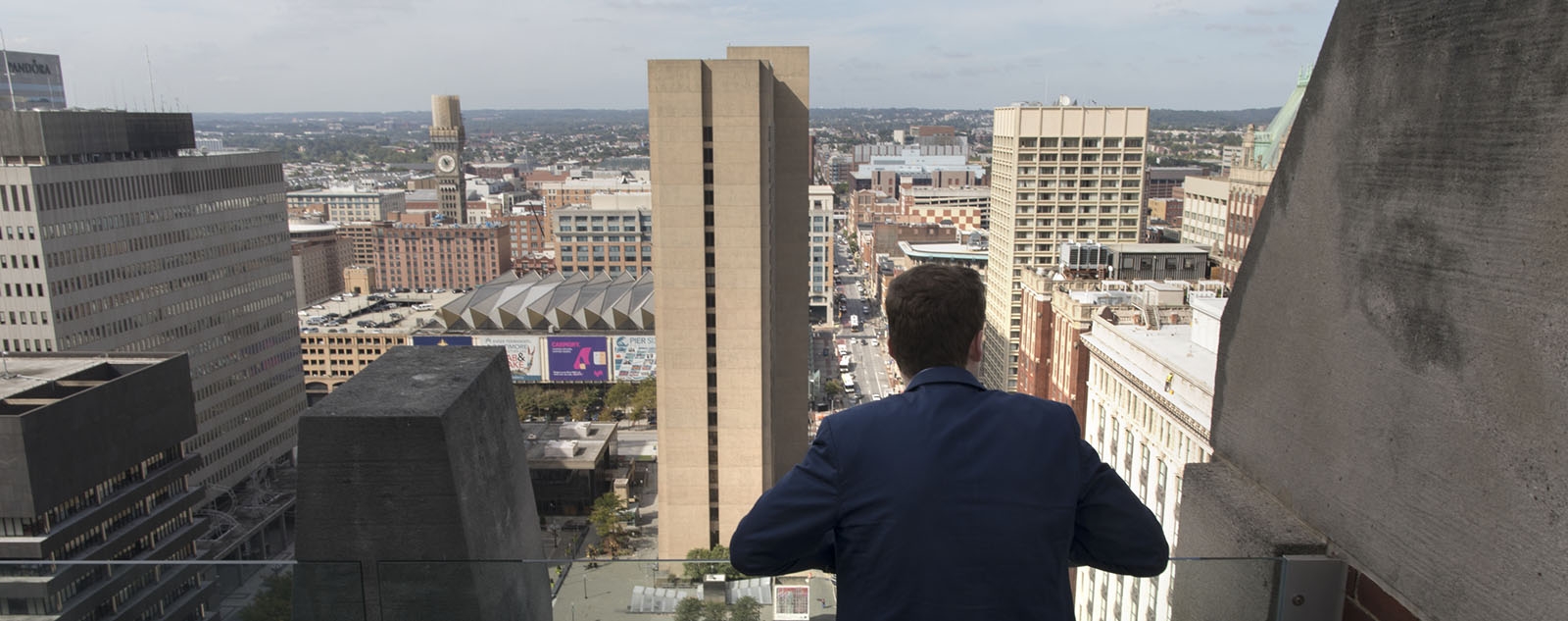 Bill King looking out from a balcony over the city of Baltimore