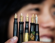 Tomoko Sakomura holds up a spray of five fountain pens