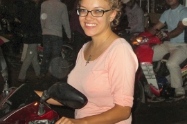 woman in glasses sitting on a motorbike