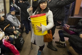 Rebecca Louie ’99 on a New York subway car with a 5-gallon bucket of compost