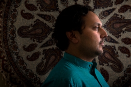 Amer Ahmed in profile, wearing a turquoise shirt