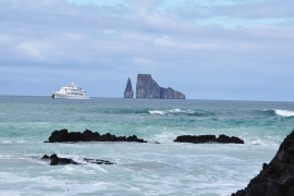 Cliffs, boat in the distance on ocean. 