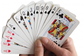 Two hands holds a deck of cards.