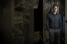 Peter Fritschel ’84 stands beside scientific equipment.