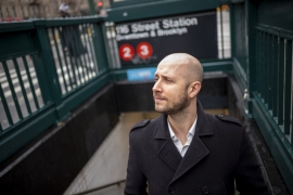 Portrait of Matt Wallaert '05 coming up from a subway stair. 