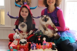 Polina Kehayova ’01, her daughter Anna, and their cats pose with an elaborate cake Polina created.