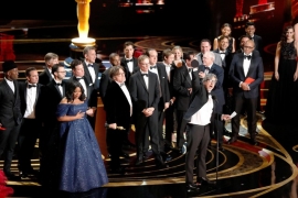 Group of actors on stage at the Oscars.