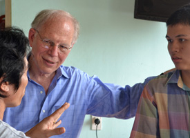 Charles Bailey '67 talks with (left) the father of Dang, 18, (right) of Hoa An ward, Da Nang. The family is in the Hope System of Care for children and young adults with disabilities. 