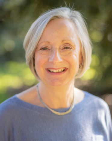 Woman with short blonde hair smiles at the camera.