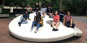 library interns seated on the button sculpture outside the University of Pennsylvania's Van Pelt Library