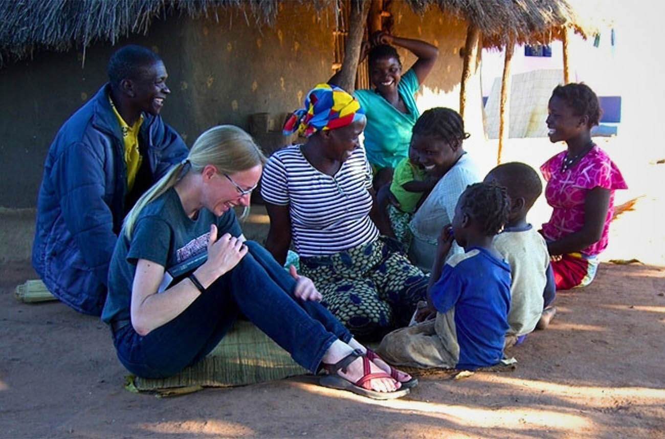 professor laughing with villagers