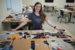Student sits at table with clothing scraps for making quilt