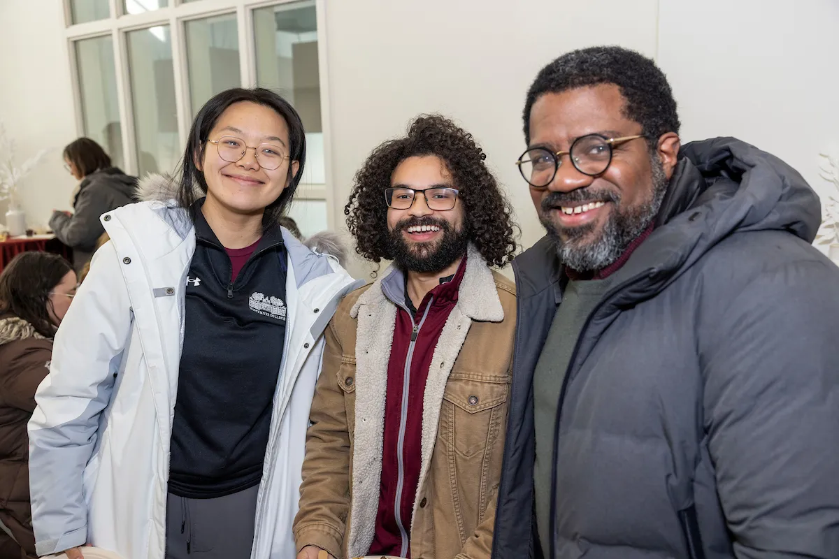 Three people standing in the lobby of the LPAC at the college's Winter Gathering reception