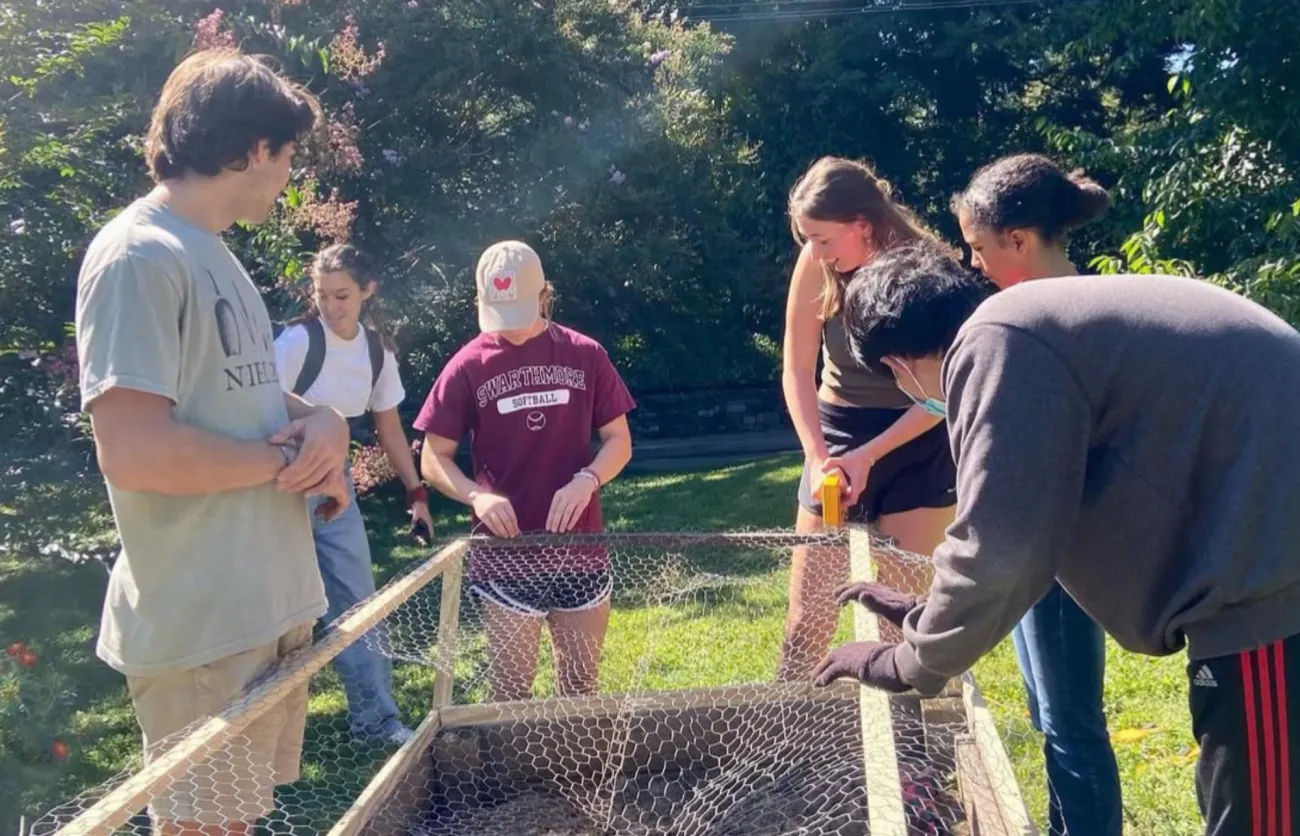 Image of a group of students at the garden stapling chicken wire to a frame