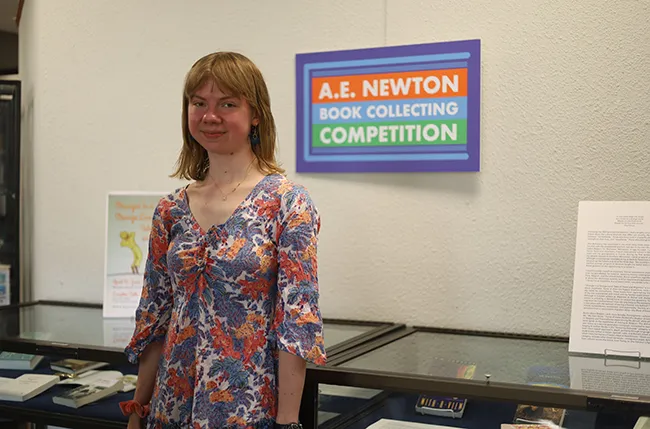 2025 Newton Award winner standing near her exhibition at the awards reception