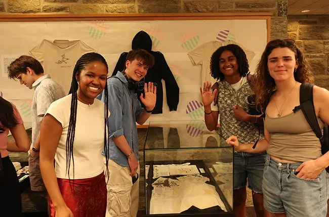 students in front of an exhibition they curated