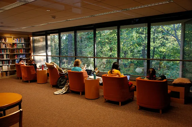 students study in Underhill Library looking out over the Crum Woods
