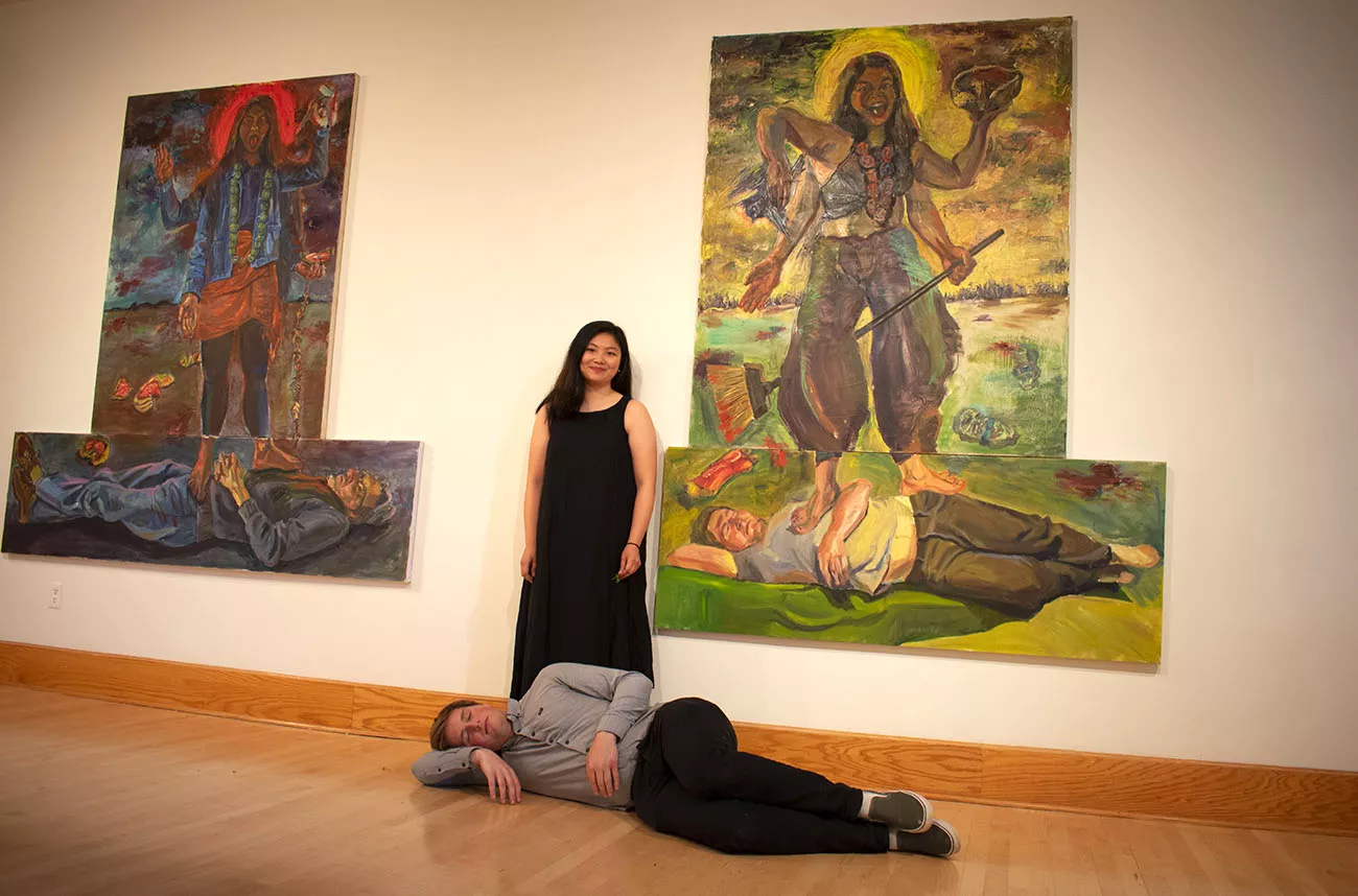 Students pose in front of paintings in List Gallery 