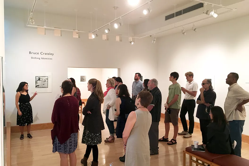 Student intern speaks to visitors in List Gallery