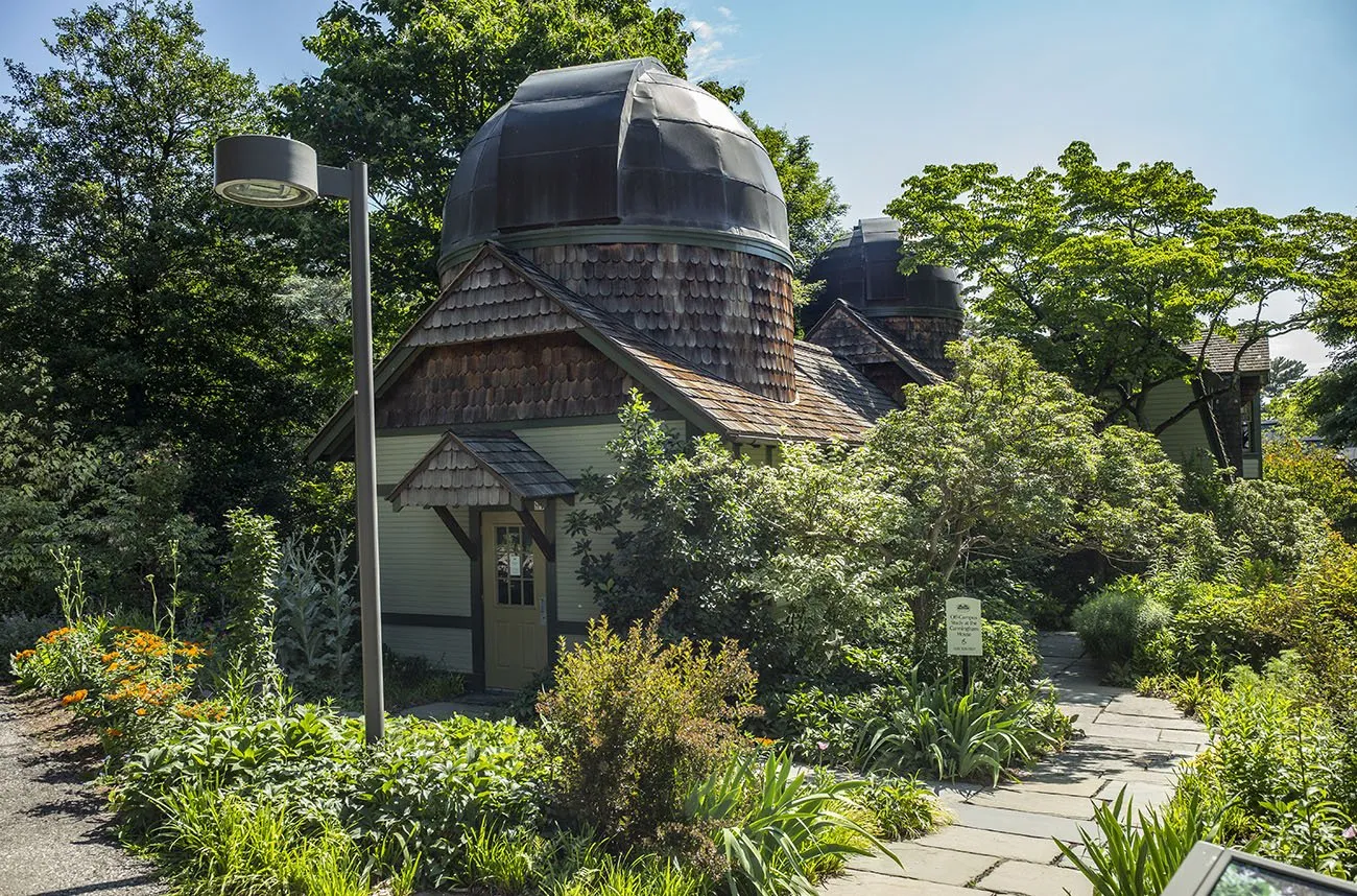 Cedar shingled observatory surrounded by trees.