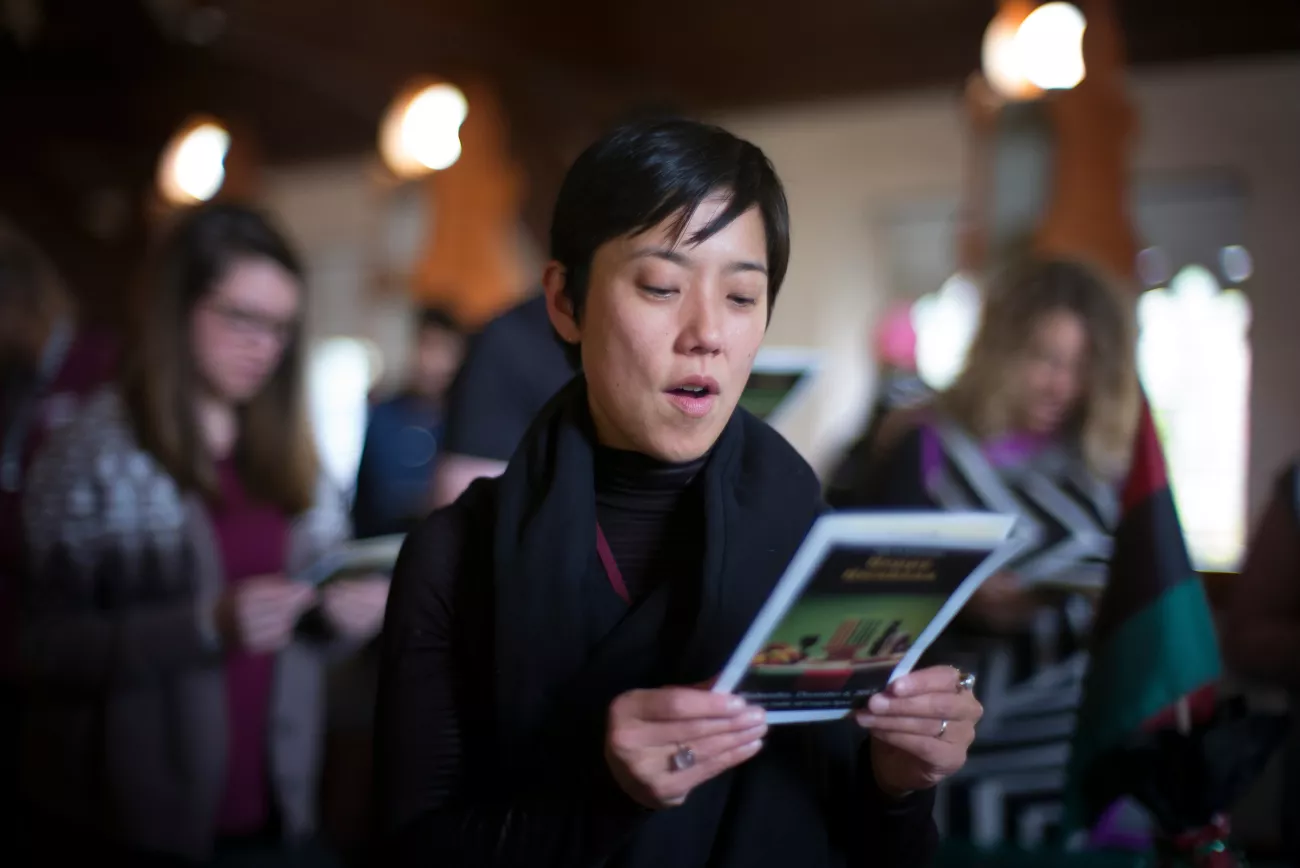 Art history professor, Tomoko Sakomura, reading a pamphlet in a crowd
