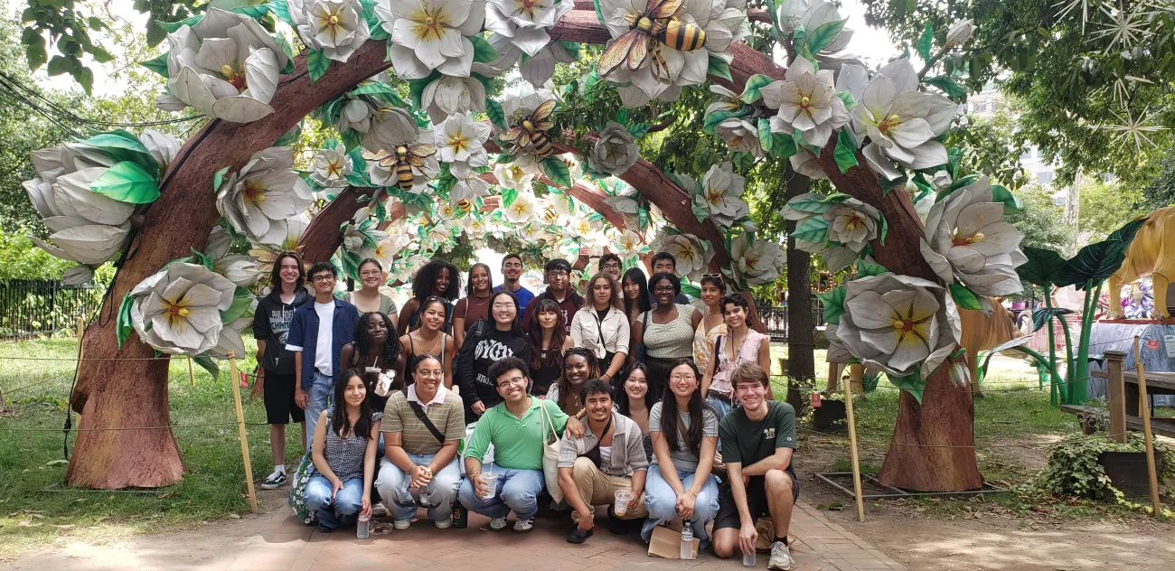 group of college students under a floral arch