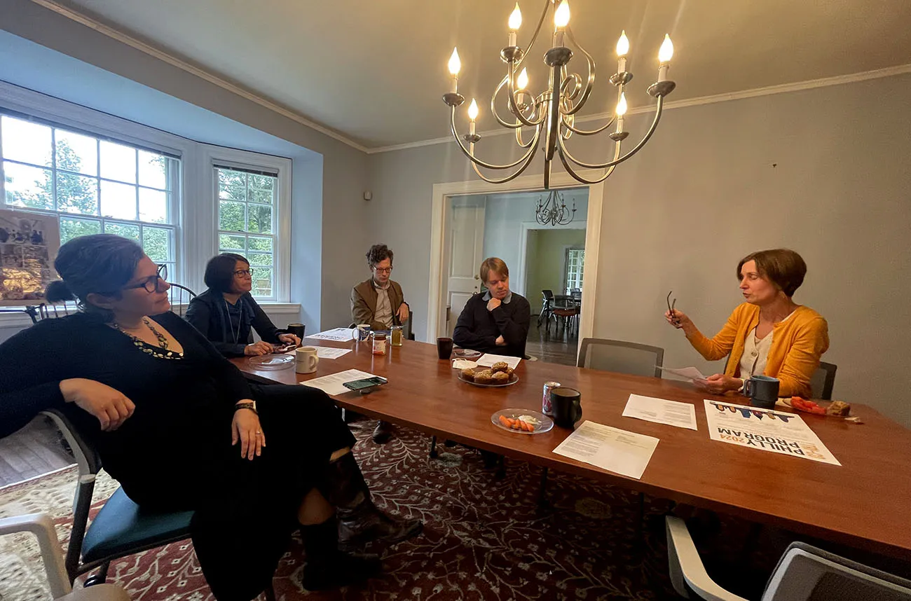 faculty talking at table with tea