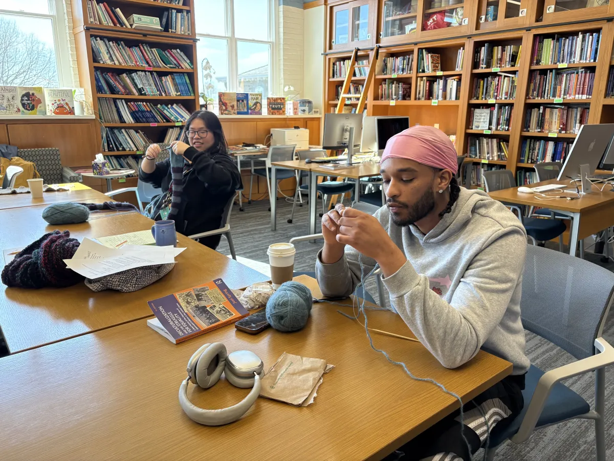a student and staff member knit in a bright library space