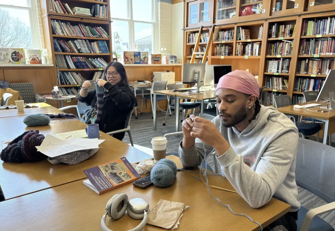 a student and staff member knit in a bright library space