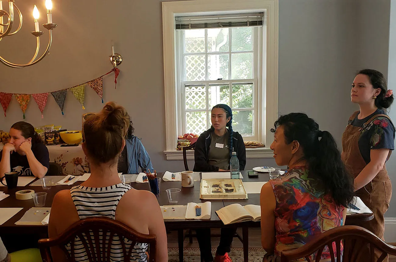 teachers gather around a table at a summer rest retreat