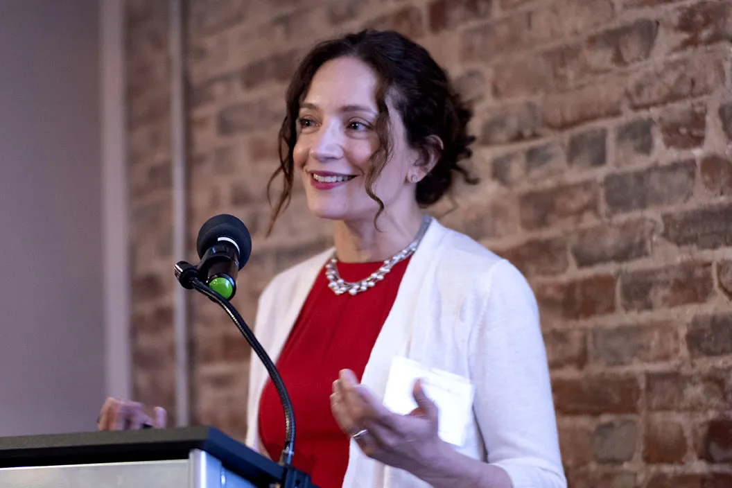 ayse speaking at a podium