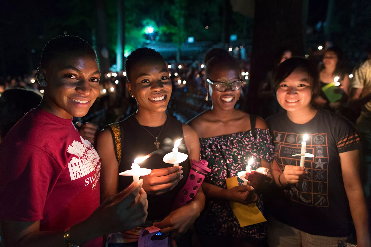 Students pose at Last Collection with candles