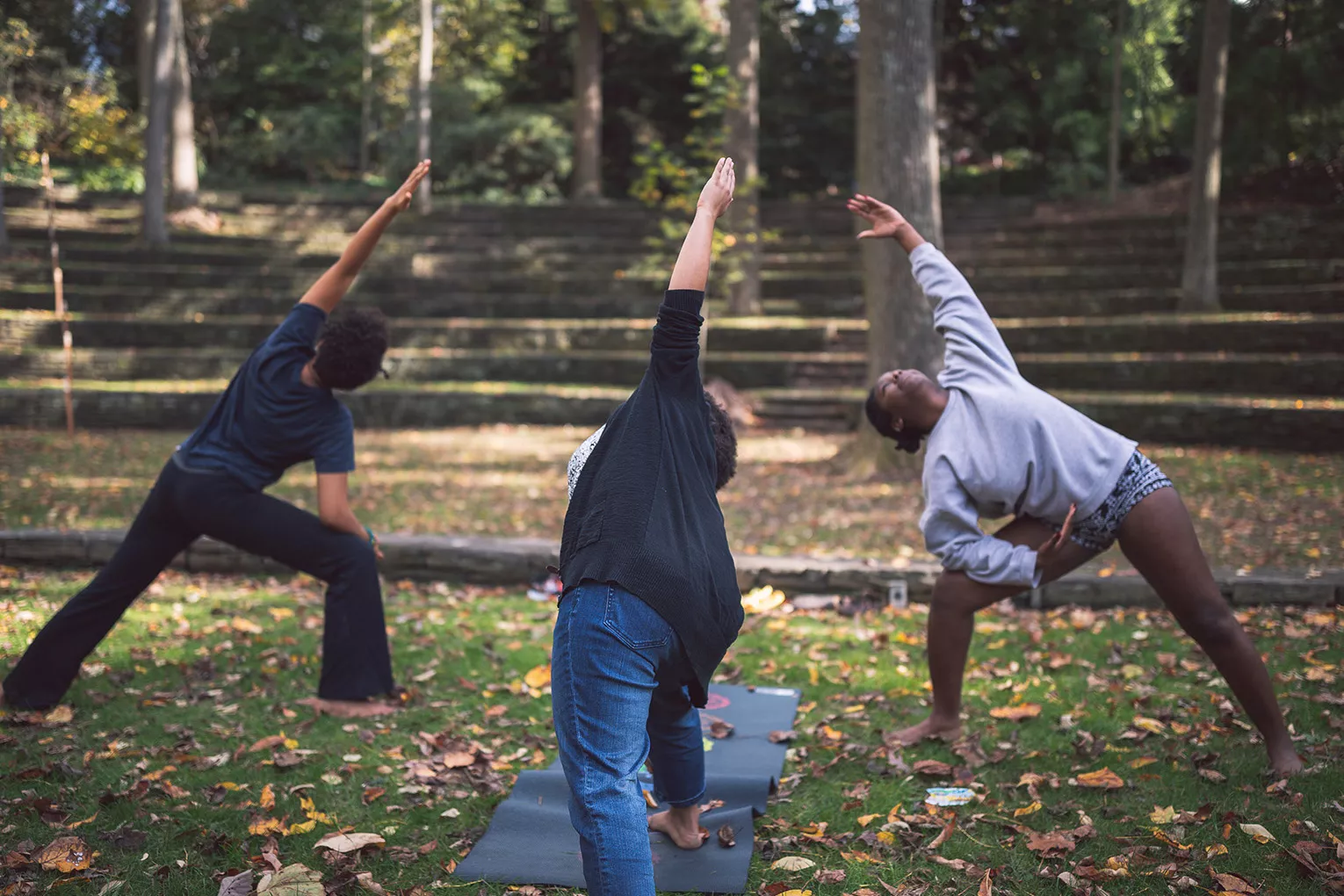 Students practice yoga in outdoor amphitheater