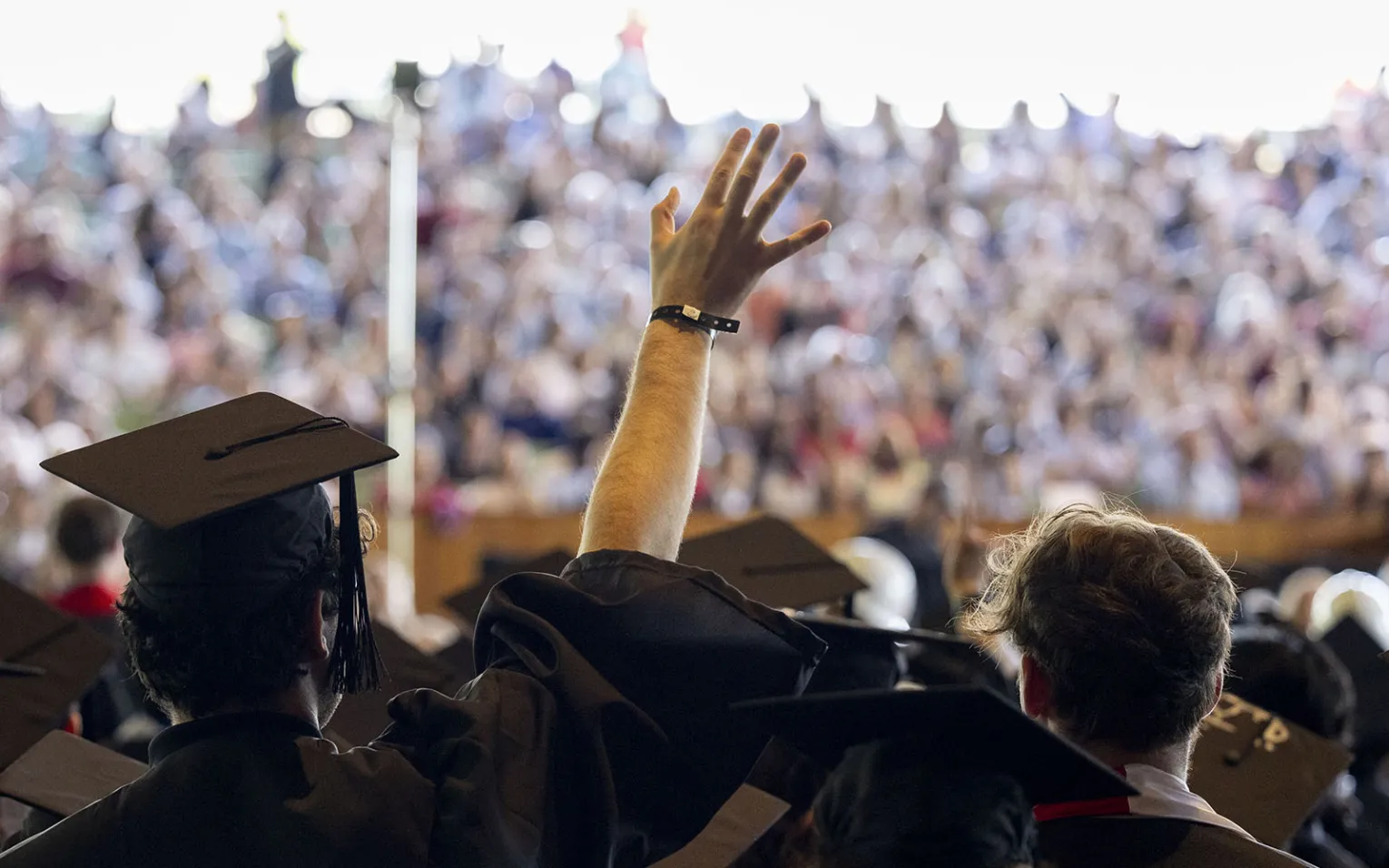 Students wave to family members at commencement