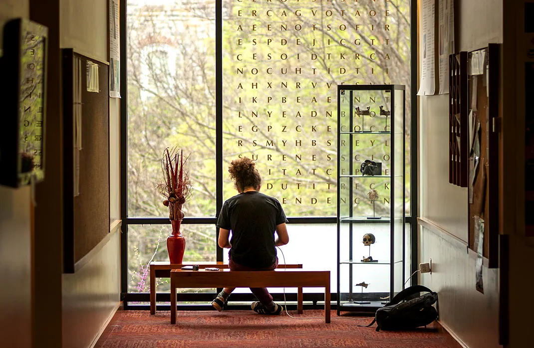 student studying in front of glass window