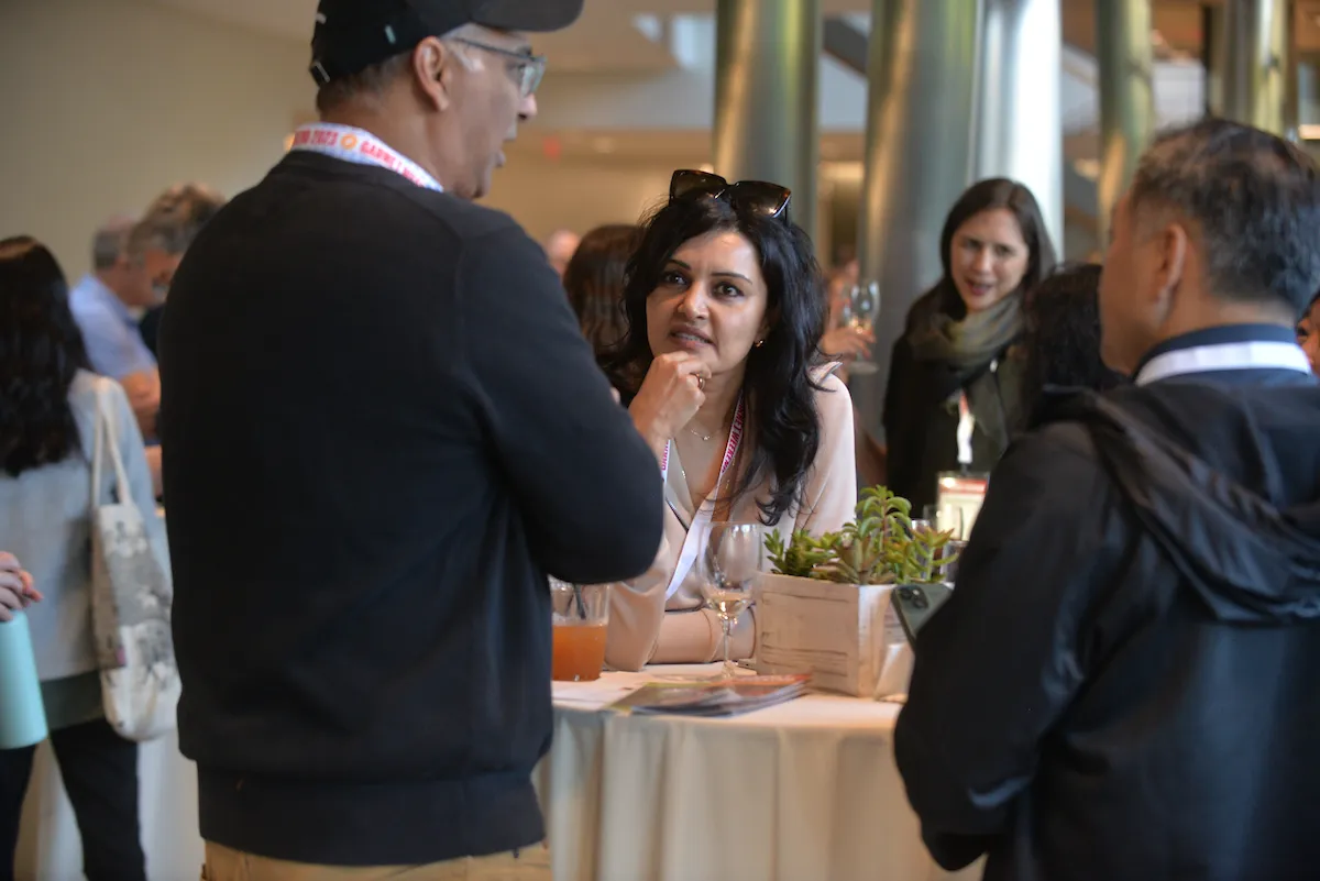 Event attendees gather around a table to talk.