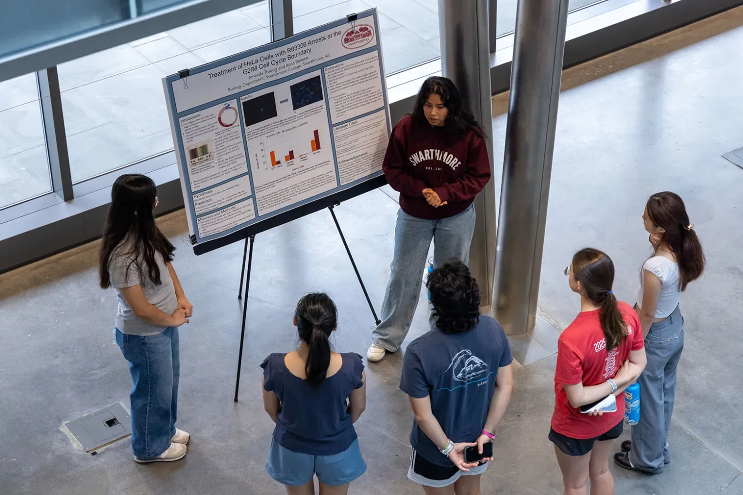 Student presenting summer research during poster presenation.
