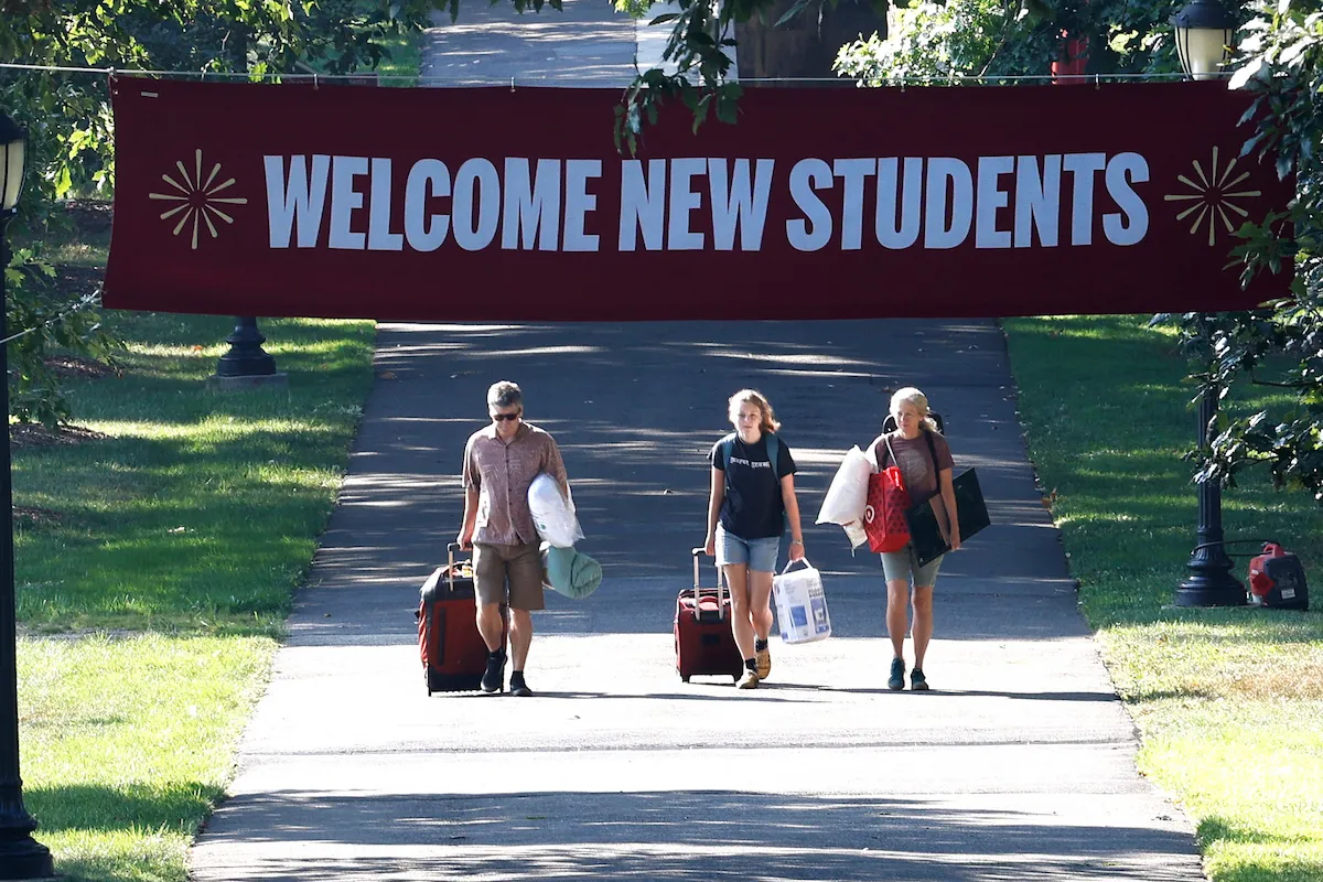 Students during move in day walk with luggage on Magill Walk