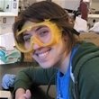 Althea Gaffney, smiling and wearing safety goggles,  gives a thumbs up for chemistry