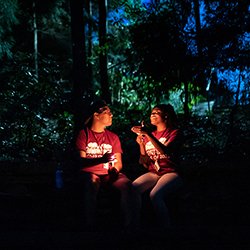 Two students hold candles at night during collection