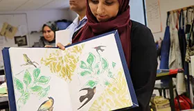 Participant with book featuring pictures of birds