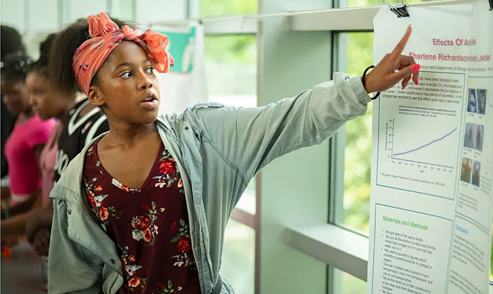 Student points to poster at science fair