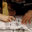 A student receives instruction on calligraphy