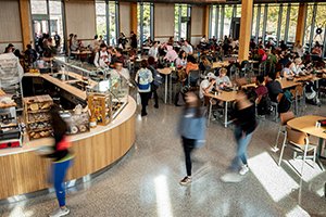 Students walk around in busy dining center