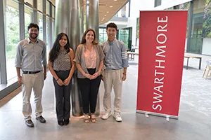Group of participants at econ conference pose with red Swarthmore banner
