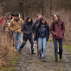 Students walk in Crum Woods on cloudy day